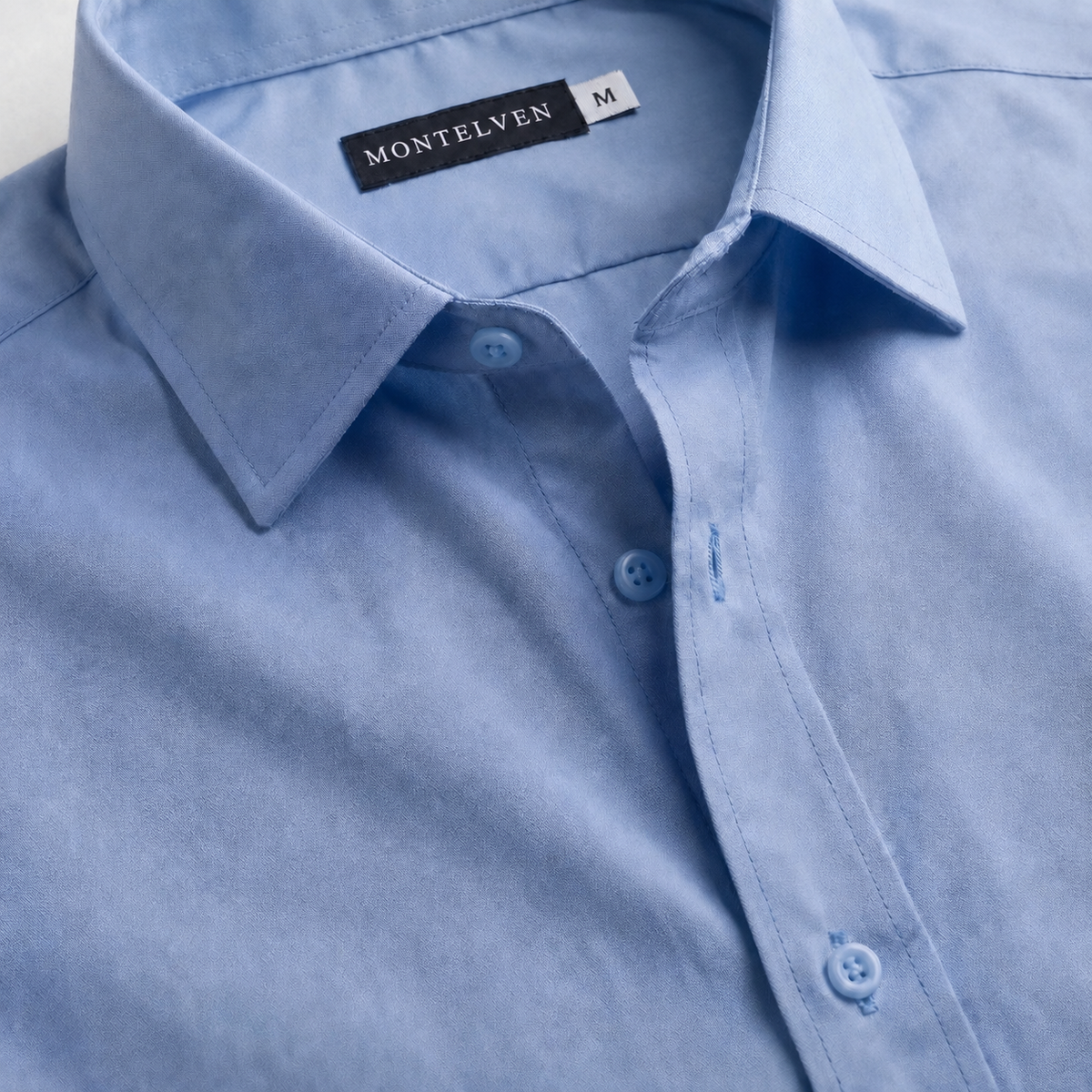 Close-up of Montelven Glatt light-blue shirt label and fabric